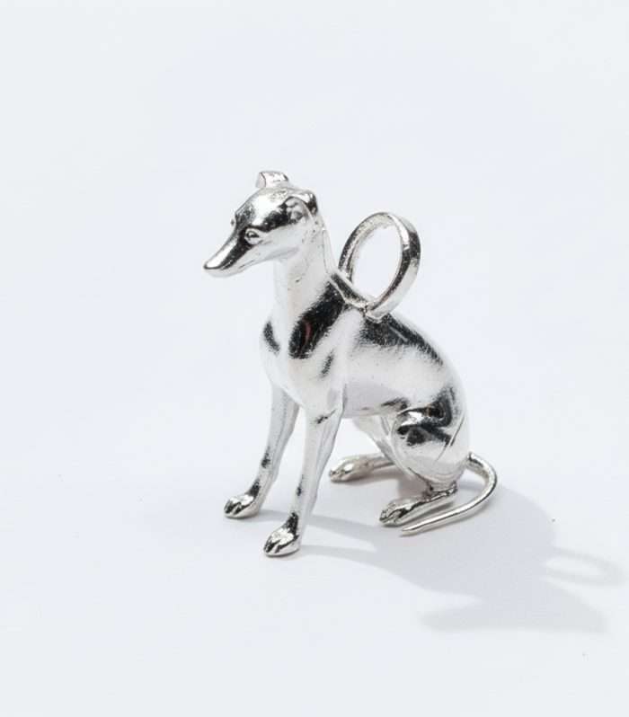 Dije de lujo "Modo Estatua (Casi)" de HUEHUE en Plata 925, mostrando la figura de un Whippet sentado en un adorable intento de quedarse quieto.