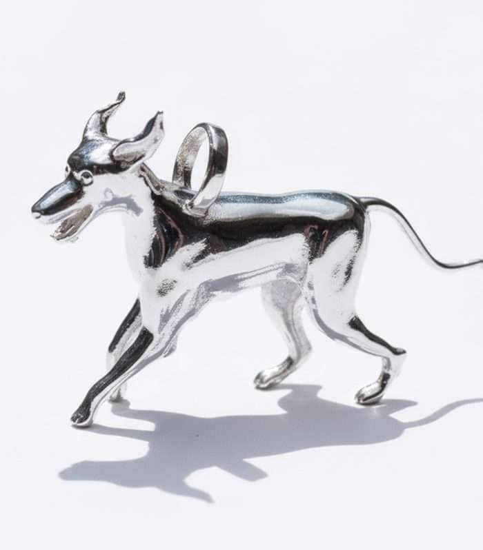 Dije de lujo "Patitas de Terremoto" en Plata 925 de HUEHUE, mostrando la figura de un Gran Danés corriendo felizmente con las orejas al viento.