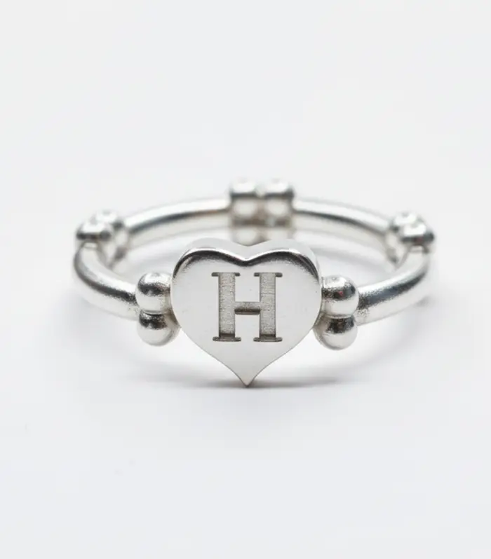 Anillo con Corazón, Huesos e Inicial de plata rodio/oro vermeil. Joyería de lujo hecha a mano, que simboliza el vínculo.