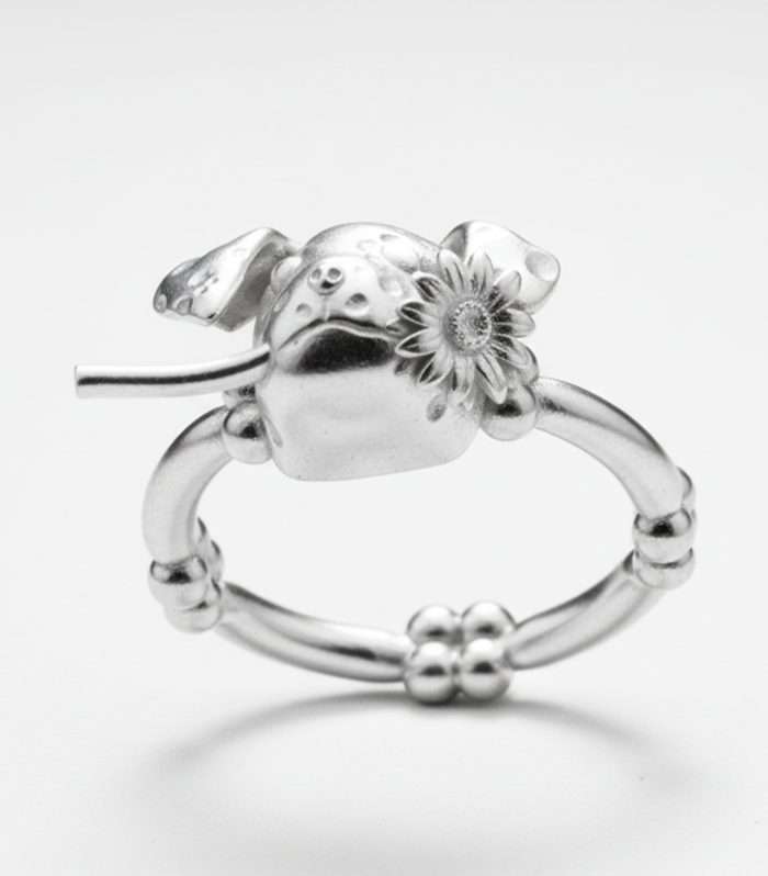 Anillo de plata con diseño de mariquita y flor, joyería artesanal y exclusiva.