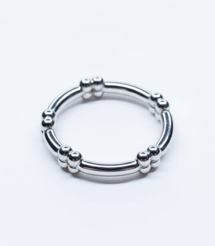 Anillo de plata con diseño de bolitas y barras, estilo minimalista y moderno.