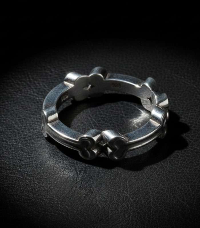 Anillo de lujo navideño "Mi Dulce Tradición" de HUEHUE, con un aro formado por cuatro huesitos de galleta de jengibre en Plata 925, sobre su estuche verde.